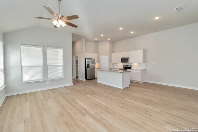 a view of kitchen with granite countertop cabinets and refrigerator