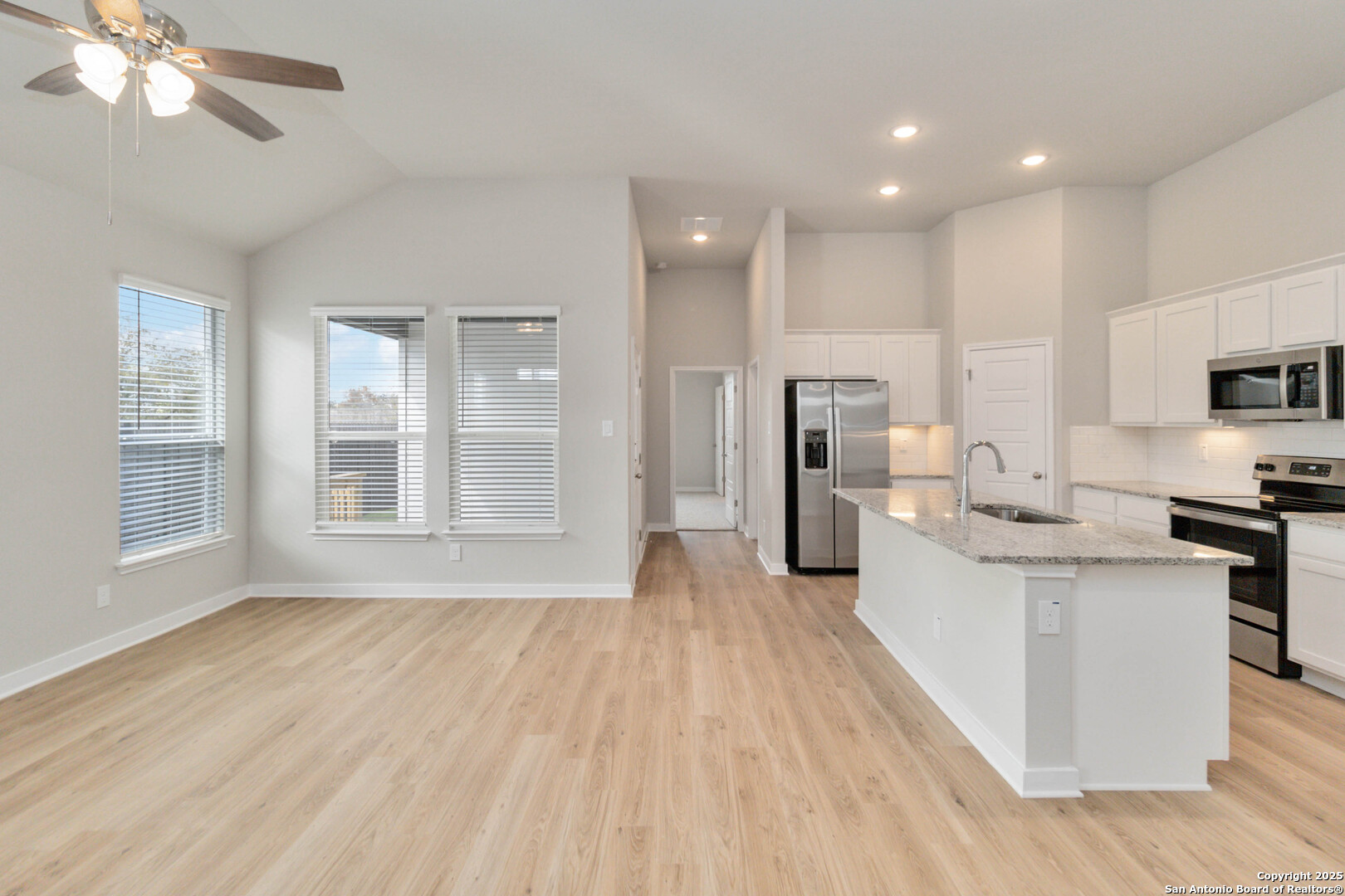 415 Cross Barn Boulevard, Unit B Buda, TX 78610 - Photo 7 of 23 a large kitchen with kitchen island a large counter top space a sink stainless steel appliances and cabinets