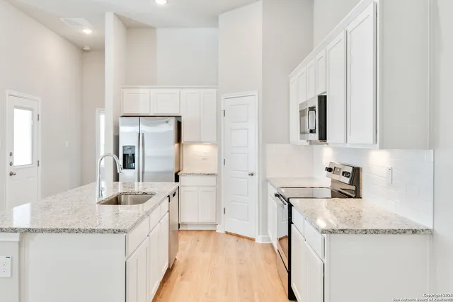a kitchen with granite countertop a sink and cabinets