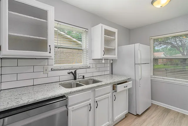 a kitchen with stainless steel appliances granite countertop a sink and a refrigerator