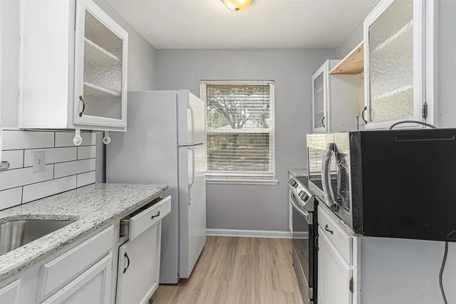a kitchen with granite countertop a refrigerator and a sink