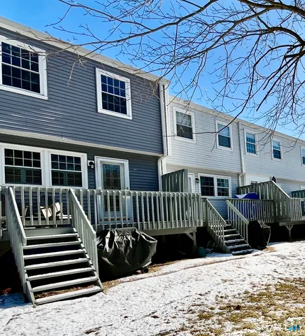 a view of a house with wooden deck front of house