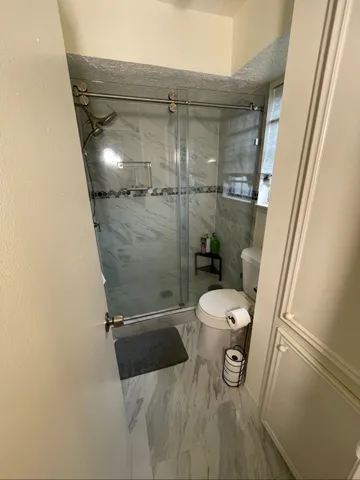 a bathroom with a toilet and a shower