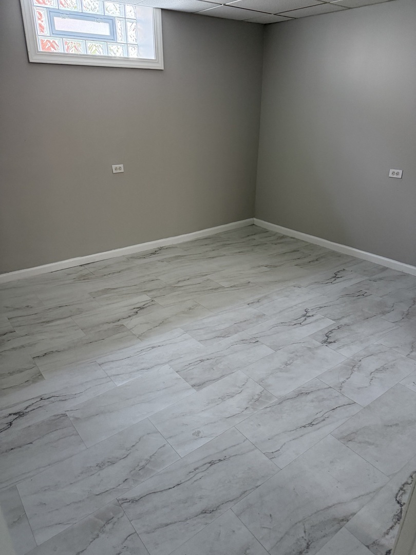 7736 West Strong Street Norridge, IL 60706 - Photo 7 of 23 an empty room with wooden floor and windows