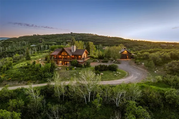 an aerial view of residential houses with outdoor space and trees