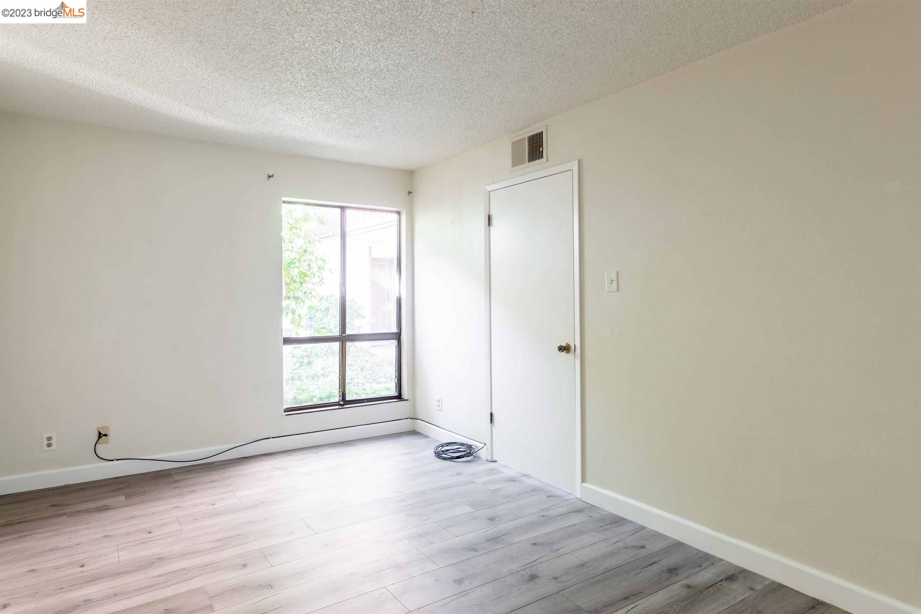 2416 Shadow Lane, Unit 75 Antioch, CA 94509 - Photo 21 of 26 an empty room with wooden floor and windows