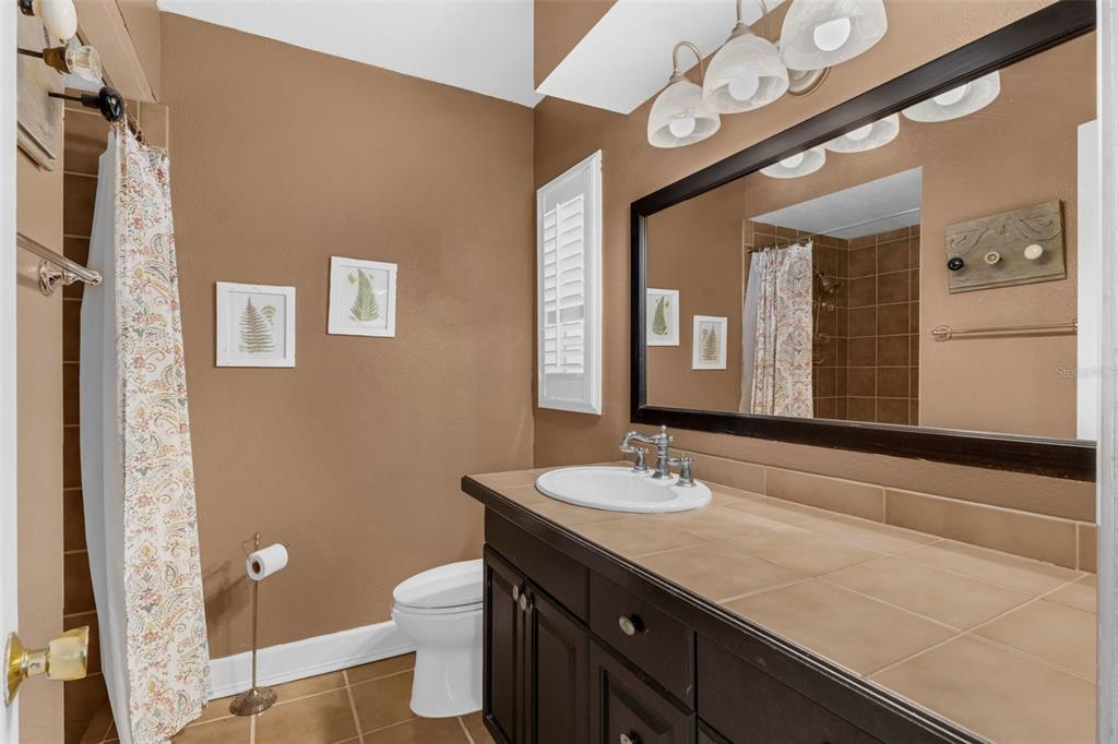 2774 Banchory Road Winter Park, FL 32792 - Photo 21 of 30 a bathroom with a granite countertop sink a toilet and a mirror