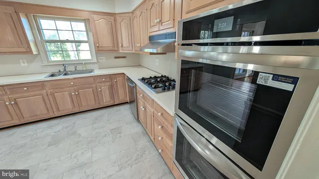 a kitchen with granite countertop a stove and a sink