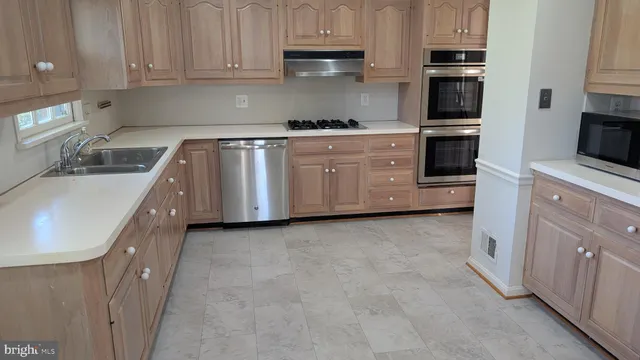 a kitchen with granite countertop a sink a stove and cabinets