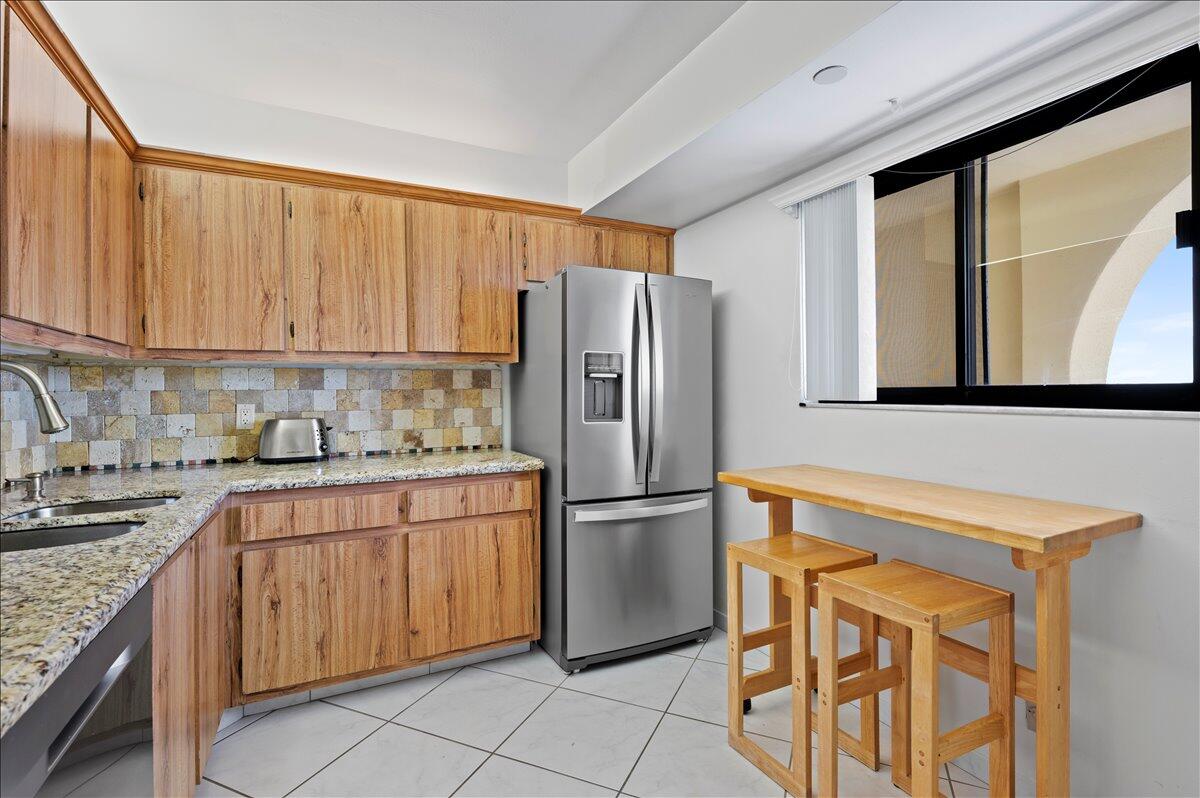 100 Ocean Trail Way, Unit 1403 Jupiter, FL 33477 - Photo 14 of 30 a kitchen with stainless steel appliances granite countertop a refrigerator sink and cabinets