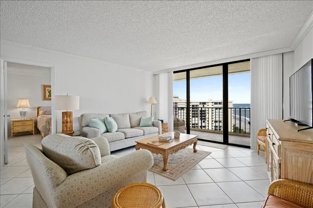 a living room with furniture and a floor to ceiling window