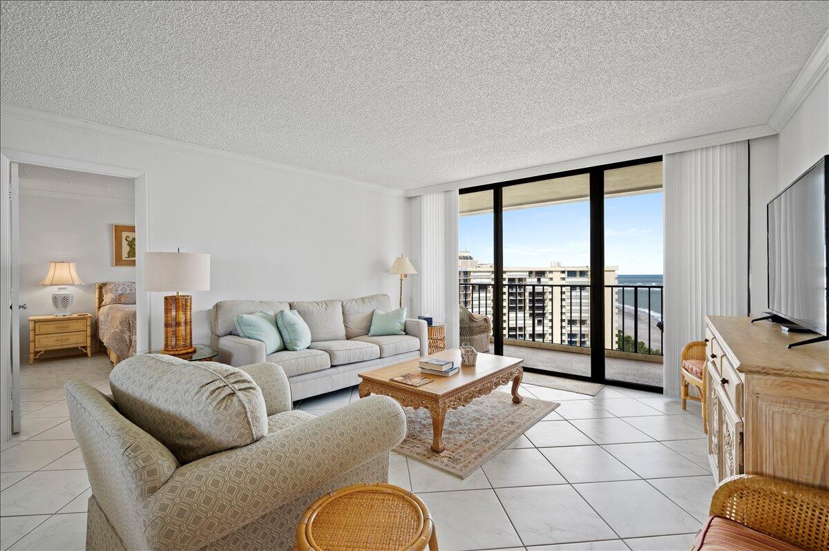 100 Ocean Trail Way, Unit 1403 Jupiter, FL 33477 - Photo 8 of 30 a living room with furniture and a floor to ceiling window