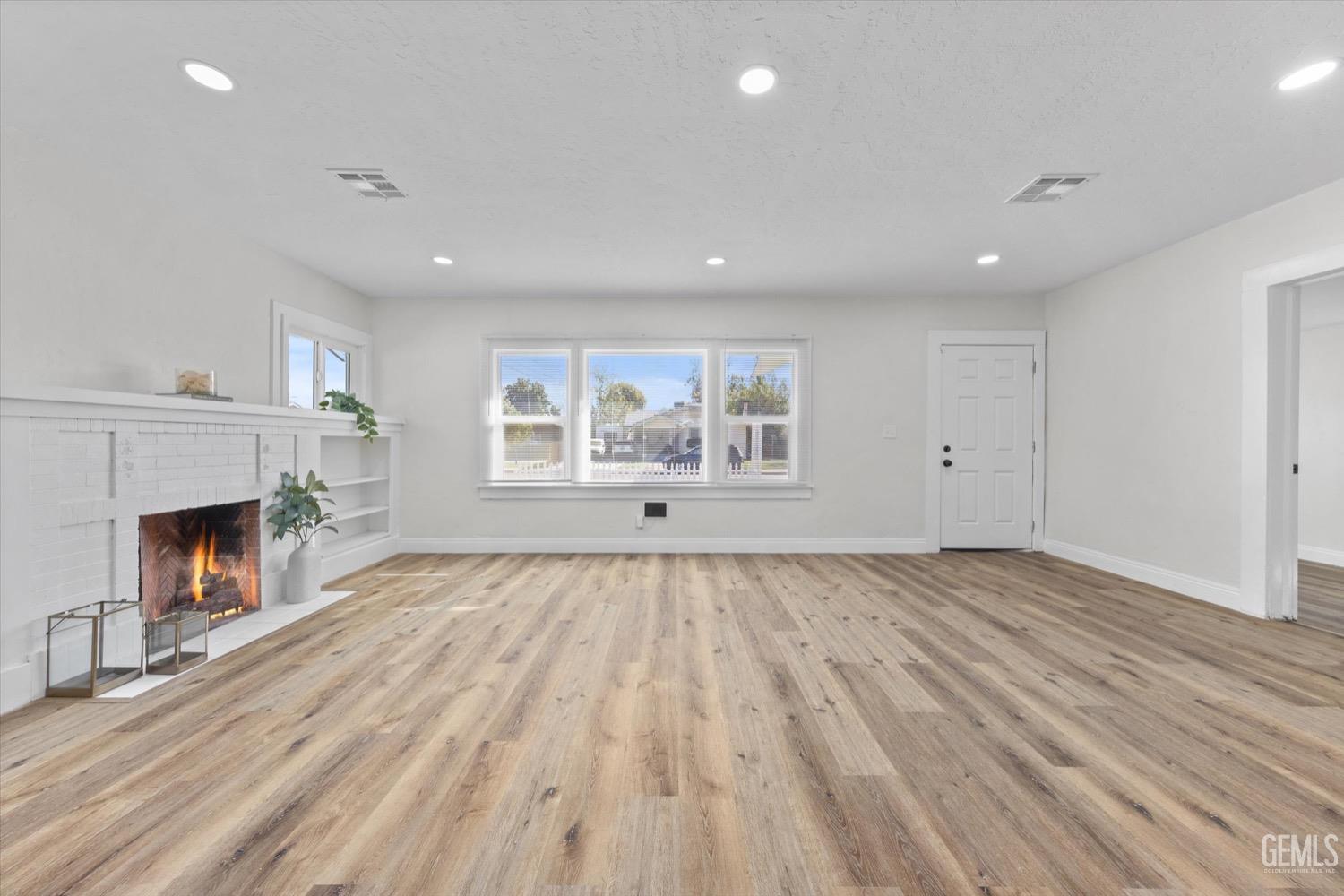 Undisclosed Address Bakersfield, CA 93304 - Photo 14 of 47 a view of empty room with wooden floor and fireplace