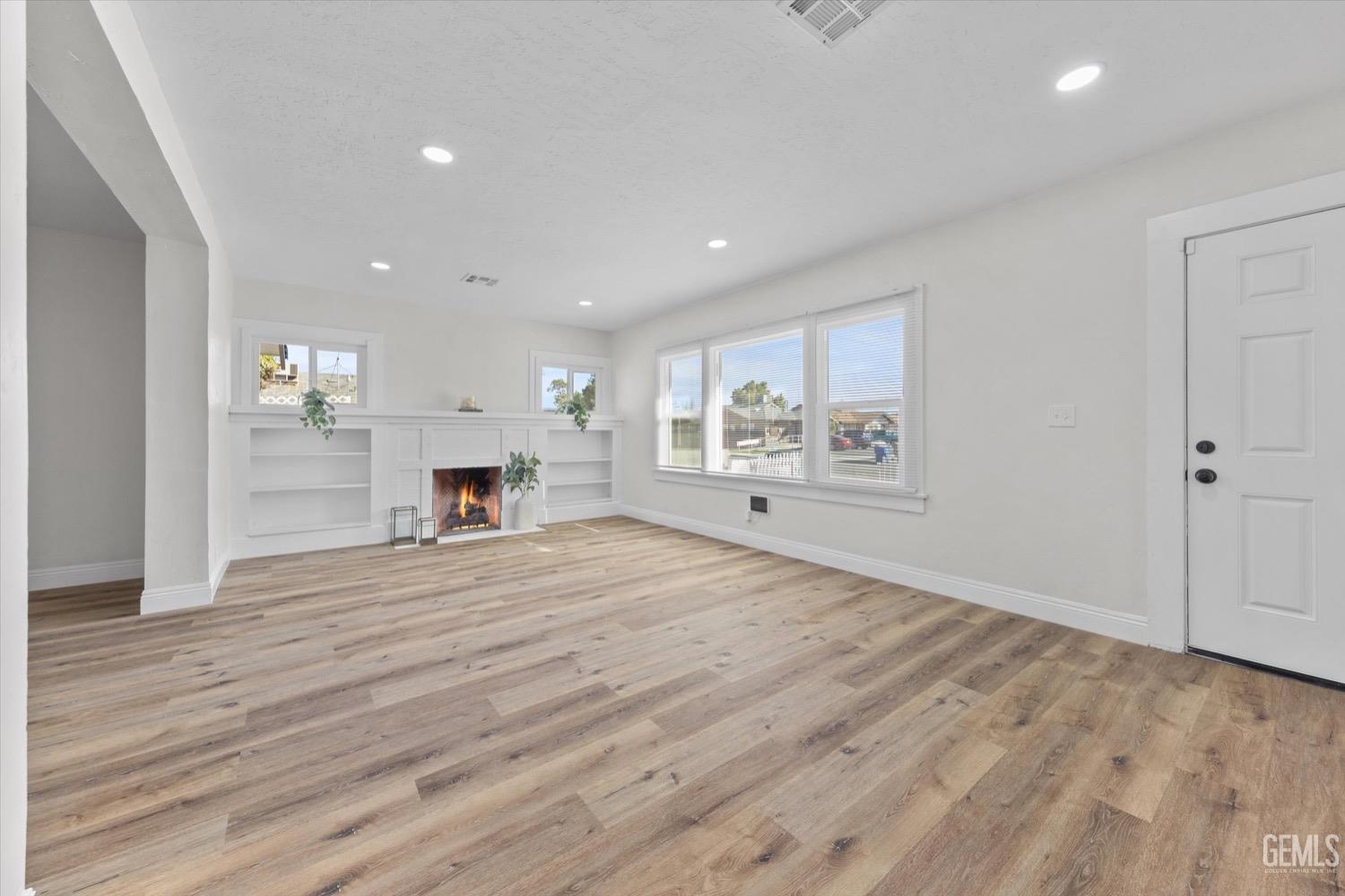 Undisclosed Address Bakersfield, CA 93304 - Photo 17 of 47 a view of empty room with wooden floor and fireplace