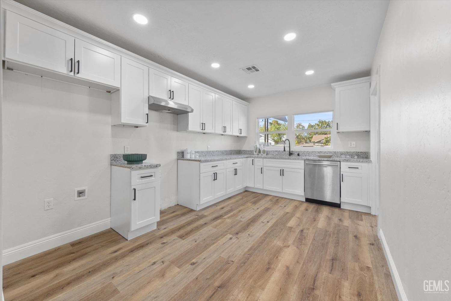 Undisclosed Address Bakersfield, CA 93304 - Photo 24 of 47 a large kitchen with stainless steel appliances granite countertop a stove a sink dishwasher and a refrigerator with wooden floors