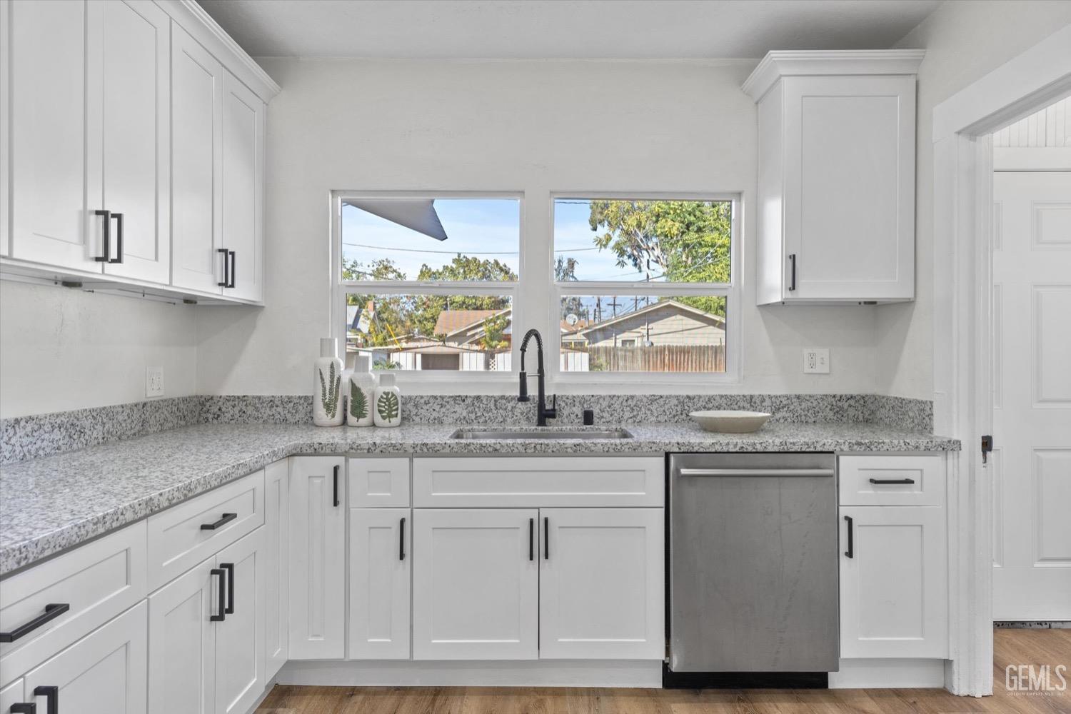 Undisclosed Address Bakersfield, CA 93304 - Photo 26 of 47 a kitchen with granite countertop white cabinets white appliances and a sink