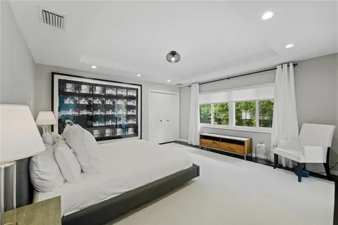 a bedroom with furniture and a large window