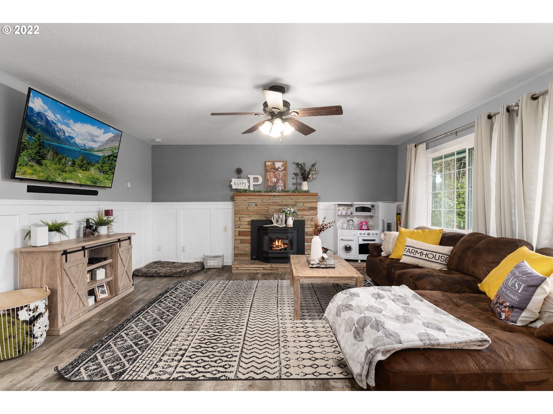 12275 Southeast School Avenue Boring, OR 97009 - Photo 3 of 14 a living room with furniture a fireplace and a flat screen tv