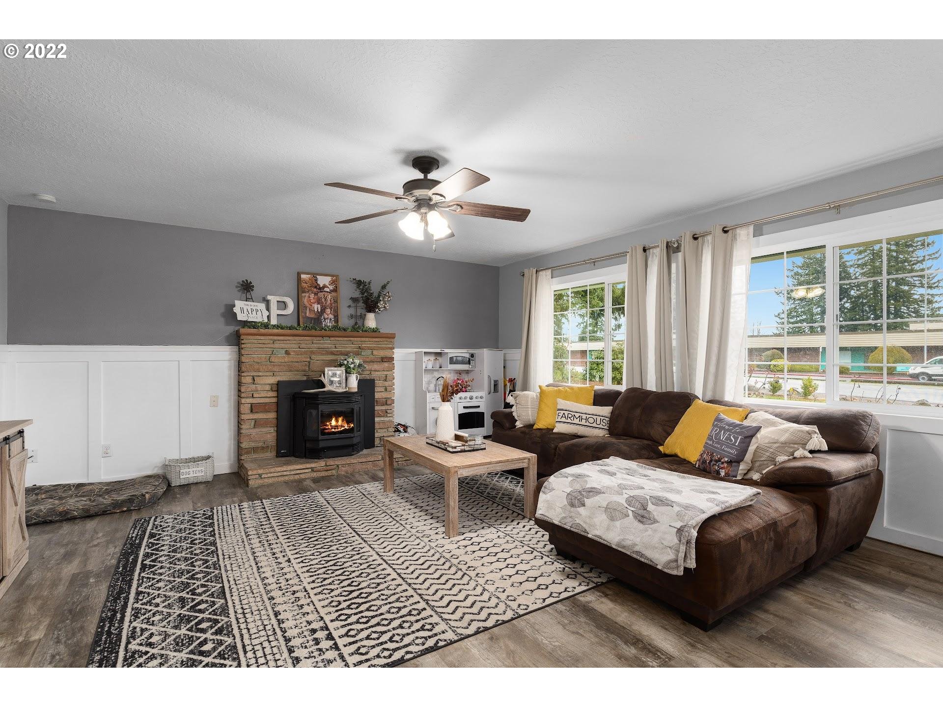 12275 Southeast School Avenue Boring, OR 97009 - Photo 4 of 14 a living room with furniture a fireplace and a large window