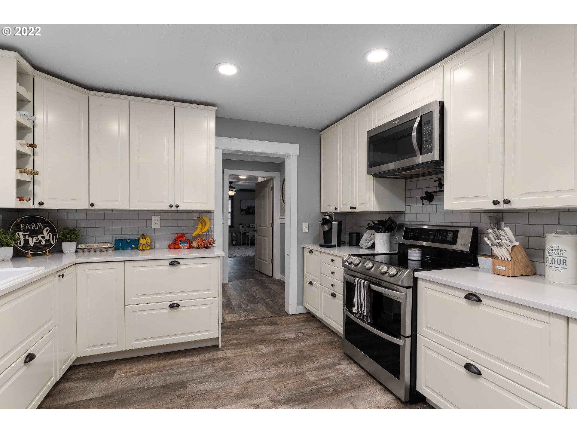 12275 Southeast School Avenue Boring, OR 97009 - Photo 9 of 14 a kitchen with stainless steel appliances granite countertop a stove a sink and a refrigerator