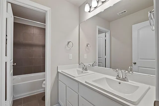 a bathroom with a double vanity sink and a mirror