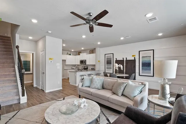 a living room with furniture kitchen and a chandelier