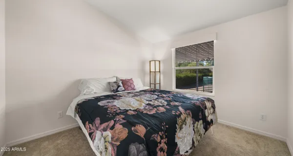 a bed sitting in a bedroom next to a window and a larger closet