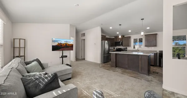 a living room with kitchen island furniture and a kitchen view