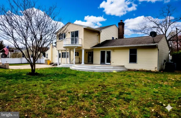 a view of a pathway of a house with plants and large tree