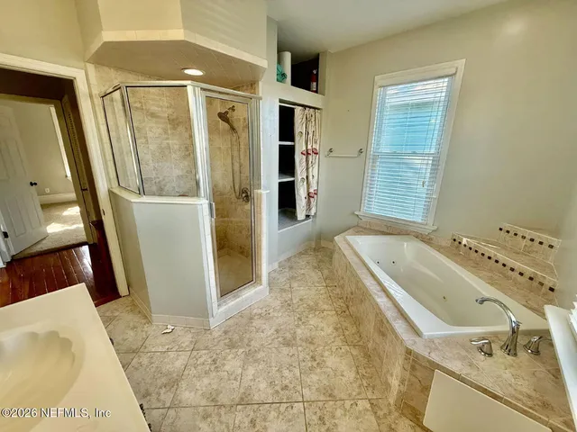a bathroom with a tub sink and mirror