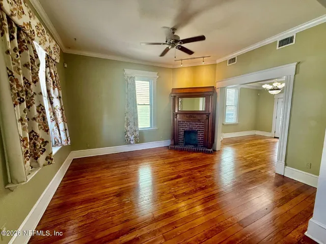 a view of empty room with wooden floor and fireplace