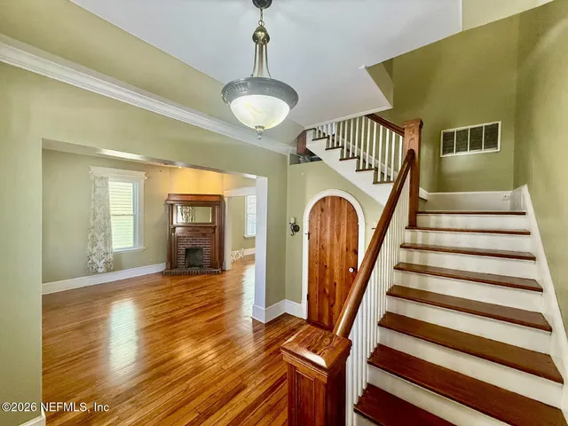 a view of entryway with wooden floor and a front door