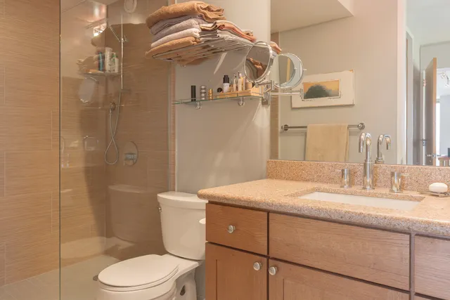a bathroom with a granite countertop sink mirror vanity and toilet
