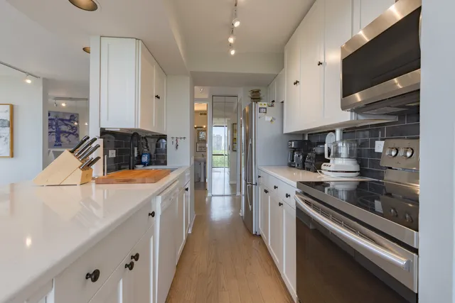 a kitchen with stainless steel appliances granite countertop a sink a stove and a refrigerator