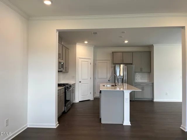 a kitchen with stainless steel appliances granite countertop a refrigerator and a stove top oven