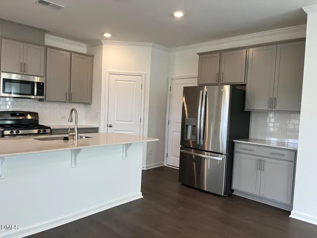 a kitchen with stainless steel appliances a refrigerator sink and microwave