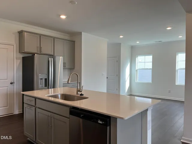 a kitchen with stainless steel appliances a sink stove and refrigerator