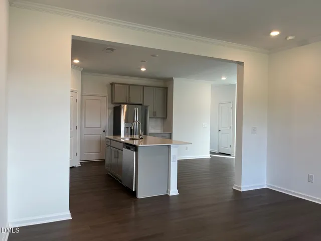 a kitchen with stainless steel appliances a refrigerator and wooden floor