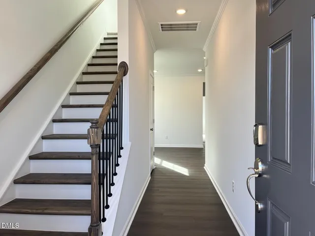 a view of a hallway with wooden floor and entryway
