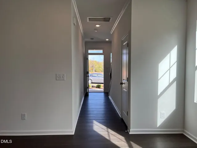a view of a hallway with wooden floor and staircase
