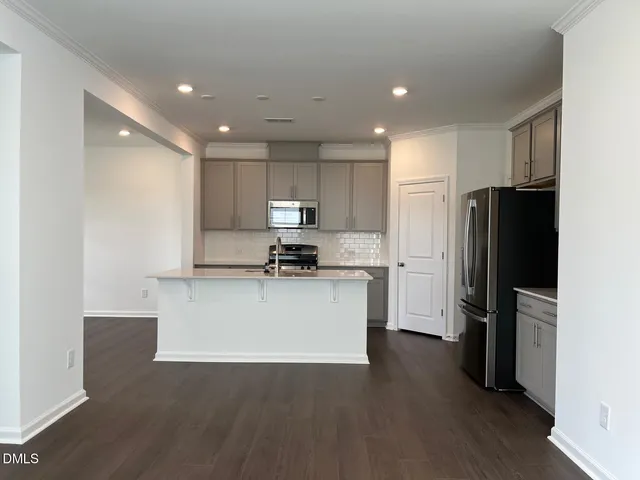 a kitchen with a refrigerator sink and cabinets