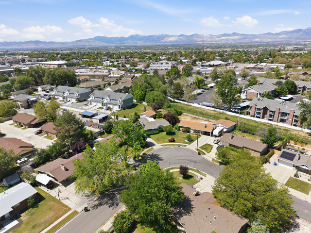 148 Tennyson Avenue Sandy, UT 84070 - Photo 53 of 55 Aerial perspective showcasing a residential neighborhood with diverse housing styles, including single-family homes and multi-story apartment buildings