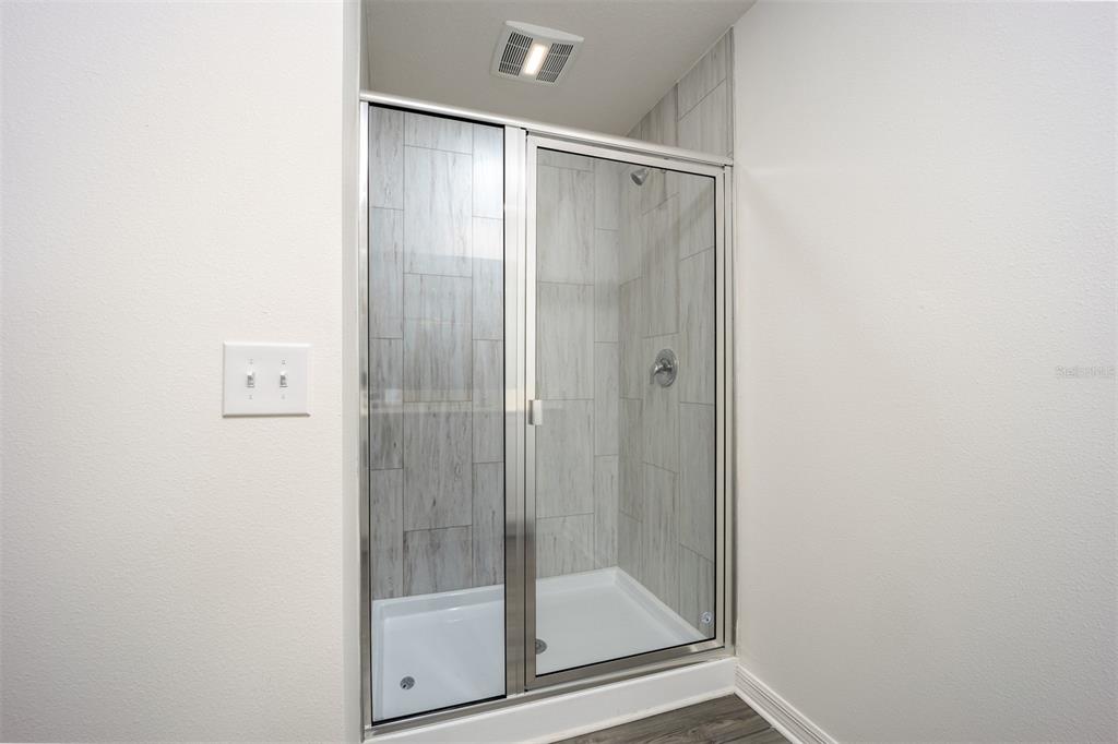 745 Poppy Lane Dundee, FL 33838 - Photo 12 of 16 a bathroom with a glass shower door