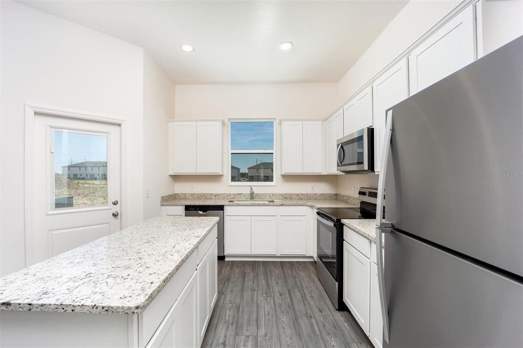 745 Poppy Lane Dundee, FL 33838 - Photo 5 of 16 a kitchen with a sink stove and refrigerator