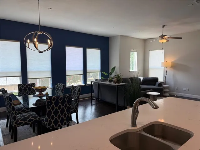 a kitchen with a dining table chairs sink and living room view