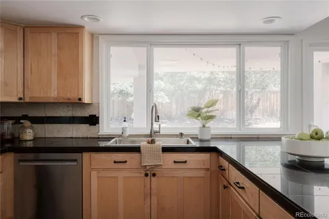 a kitchen with stainless steel appliances a sink a window and cabinets