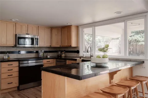 a kitchen with stainless steel appliances granite countertop a stove a sink and a microwave