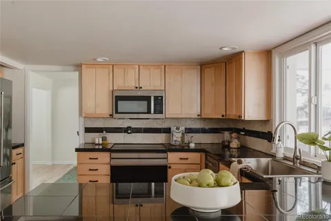 a kitchen with granite countertop a sink and white cabinets
