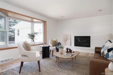 a living room with furniture a rug and a large window