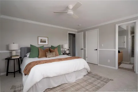 a spacious bedroom with a bed and a lamp